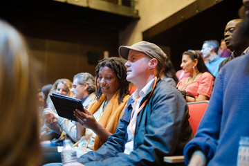 Attentive businesswoman taking in notes in conference audience