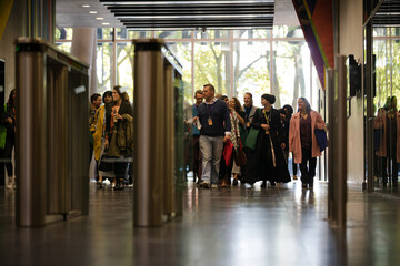 People entering auditorium hallway