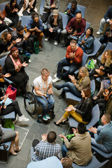 Speaker in wheelchair on stage talking to conference audience