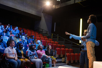 Male speaker on stage talking to audience
