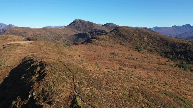 Orbiting a person running on a mountain in Volda, Norway. Drone shot