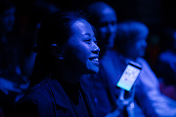 Smiling, enthusiastic woman cheering in audience