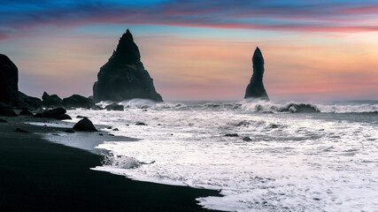 Vik and Basalt Columns at sunset, Black Sand Beach in Iceland.