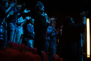 Audience clapping in dark room