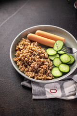 buckwheat porridge with sausages and cucumber salad fresh portion ready to eat meal snack on the table copy space food background rustic. top view keto or paleo diet