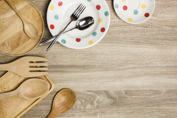 Wooden utensils and polka dot plant on wooden background.