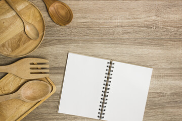 A book with utensils on wooden table