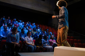 Male speaker on stage talking to audience