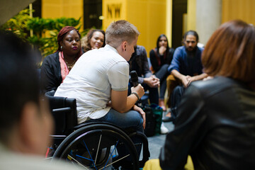 Audience watching speaker in wheelchair talking on stage