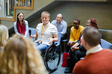 Audience watching male speaker in wheelchair talking on stage