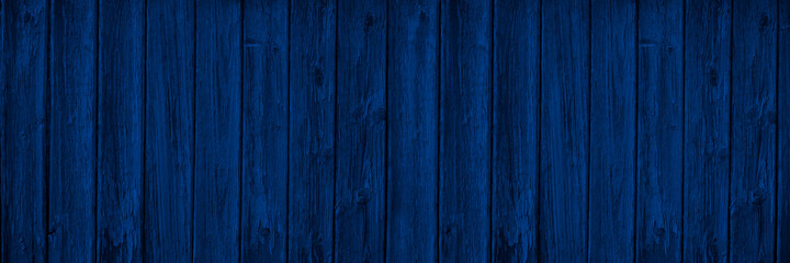 Dark blue wood background with copy space for design. Wide banner. Painted wood planks.