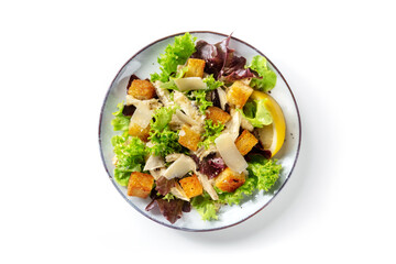 Chicken Caesar salad, overhead shot on a white background. Romaine leaves, crispy croutons and...