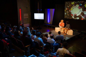 Conference audience watching speakers on stage