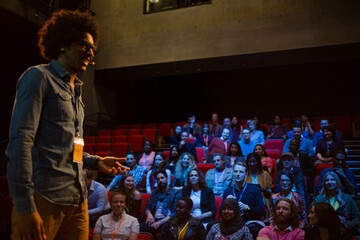 Male speaker on stage talking to audience