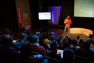 Male speaker on stage talking to audience