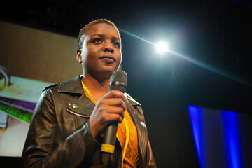 Female speaker on stage talking to audience