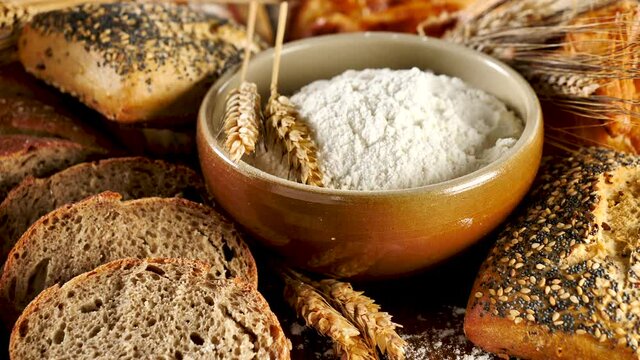 assorted of bread with bowl of flour and wheat