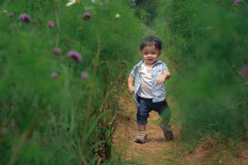 A little boy cute run on a road in the forest. (Soft photo with blurring and selective focus)