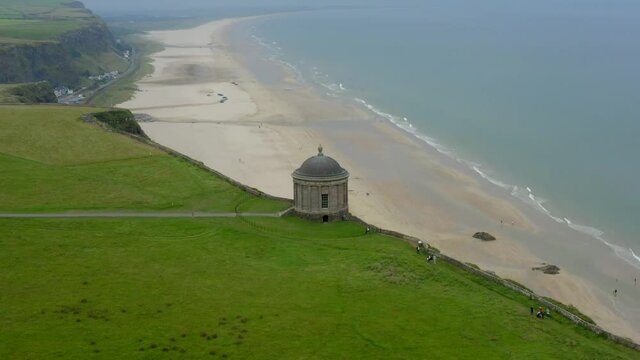 Mussenden Temple, Downhill Estate, Coleraine, County Derry, Northern Ireland, September 2021. Drone orbits while descending favoring the cliffs and eastern side with Downhill house in the background.