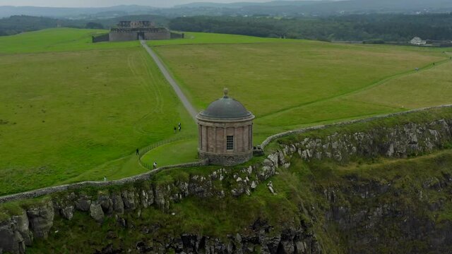 Mussenden Temple, Downhill Estate, Coleraine, County Derry, Northern Ireland, September 2021. Drone orbits while ascending favoring the cliffs and eastern side with Downhill beach in the background.