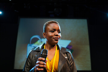 Female speaker on stage talking to audience