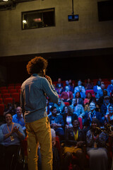 Male speaker on stage talking to audience