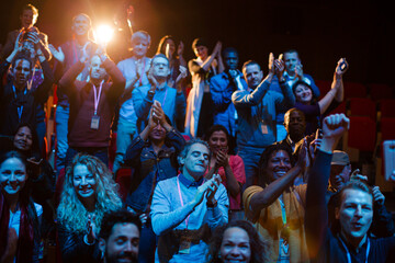 Smiling, excited audience cheering