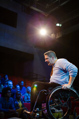 Fototapeta na wymiar Speaker in wheelchair on stage talking to conference audience