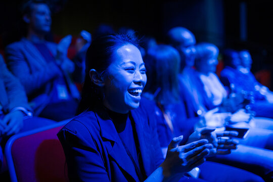 Smiling, enthusiastic woman cheering in audience