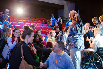 Female speaker in hijab on stage talking to audience