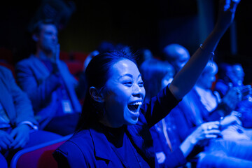 Smiling, enthusiastic woman cheering in audience