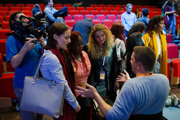 Fototapeta premium Audience talking to speakers in wheelchairs on stage