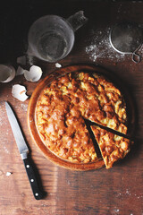 Apple Pie on a Wooden Plate with a Piece of Pie Cut Out