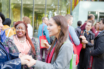 Three women greeting outside auditorium
