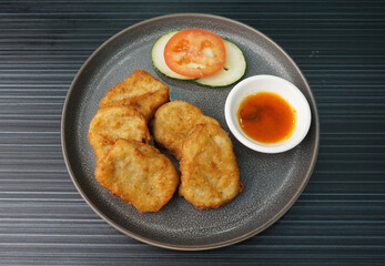 deep fried golden chicken nugget fritter with sauce on dark grey wood background dim sum halal menu
