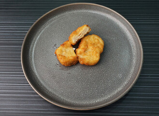 deep fried golden chicken nugget fritter with sauce on dark grey wood background dim sum halal menu