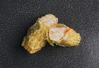 deep fried golden long fish paste wrapped in beancurd skin lobar wuxiang on dark grey wood background dim sum halal menu