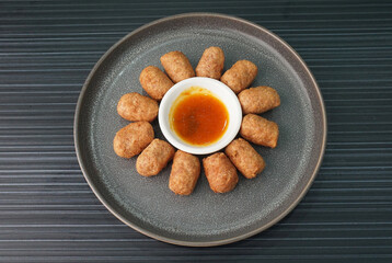 deep fried mini hot dog sausage luncheon meat with spicy sauce on dark grey wood background dim sum halal menu