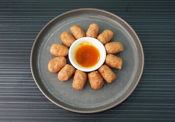 deep fried mini hot dog sausage luncheon meat with spicy sauce on dark grey wood background dim sum halal menu