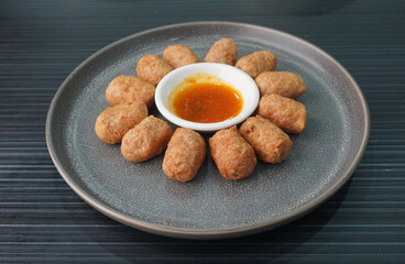 deep fried mini hot dog sausage luncheon meat with spicy sauce on dark grey wood background dim sum halal menu
