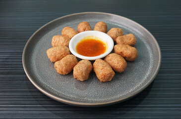 deep fried mini hot dog sausage luncheon meat with spicy sauce on dark grey wood background dim sum halal menu