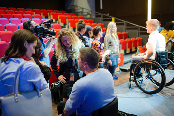 Audience talking with male speaker in wheelchair