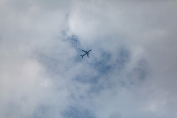 Fototapeta na wymiar the plane is flying high in the sky between the clouds