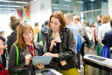Businesswomen in conference audience using digital tablet