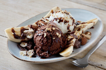Sweet banana split dessert on wooden table