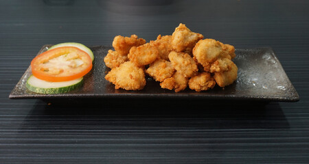 deep fried golden chicken popcorn fritter on dark grey wood background asian dim sum halal food restaurant cuisine banquet menu for cafe