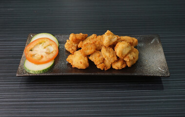 deep fried golden chicken popcorn fritter on dark grey wood background dim sum halal menu