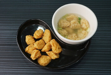 deep fried golden fish prawn ball seafood in dry or soup bowl on dark grey wood background asian dim sum halal food restaurant cuisine banquet menu for cafe