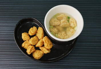 deep fried golden fish prawn ball seafood in dry or soup bowl on dark grey wood background dim sum halal menu