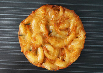 deep fried crispy golden fresh prawn fritter pan cake in round shape on dark grey wood background dim sum halal menu